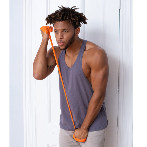 Homme faisant des exercices pour la poitrine et les bras avec une bande de résistance orange.