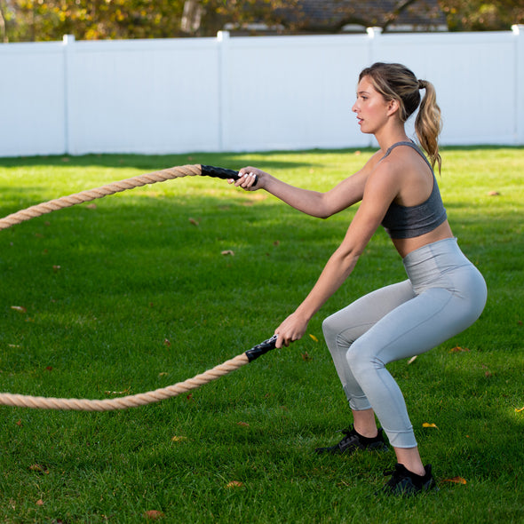 Une femme fait de l'exercice avec une corde de combat GoZone de 6 mètres.