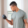 Side view of man performing biceps curls with rubber hex dumbbell