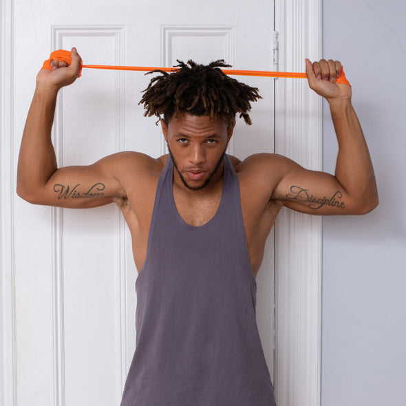 Man doing arm/chest exercise with orange resistance band