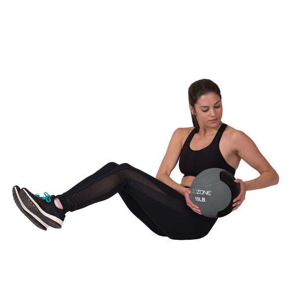 Woman on white background performing a Russian twist with the medicine ball