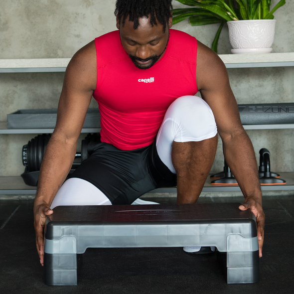 Man preparing to use aerobic step with risers added